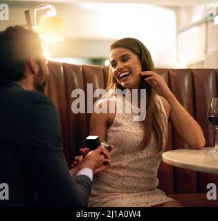 Passiamo il resto della nostra vita insieme. Scatto di un giovane che propone alla sua ragazza una cena romantica. Foto Stock