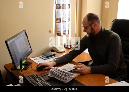 Dipendente del Servizio migrazione, che opera in modo potenziato per rilasciare passaporti ai cittadini della regione e IDP per quanto riguarda la situazione nel paese, Ivano-Frankivsk, Ucraina occidentale, 22 marzo 2022. Foto di Yurii Rylchuk/Ukrinform/ABACAPRESS.COM Foto Stock