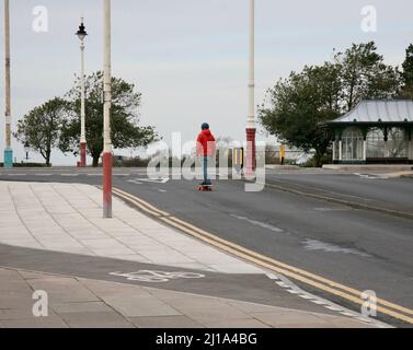 Un giovane skateboarder in mezzo alla strada Foto Stock