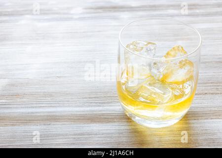 whisky singolo di scotch di malto sulle rocce su tavola grigia di legno con copyspace Foto Stock