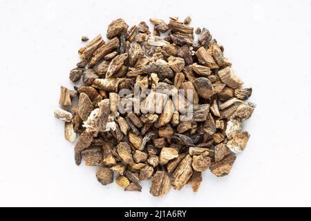 vista dall'alto di un mucchio di radici di burdock essiccate tritate su un piatto grigio Foto Stock