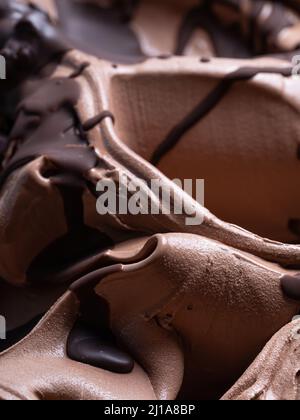 Gelato al cioccolato - dettaglio telaio completo. Primo piano di una superficie marrone di gelato al cioccolato ricoperto con una guarnizione di cioccolato fondente. Foto Stock