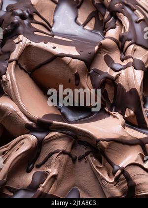 Gelato al cioccolato - dettaglio telaio completo. Primo piano di una superficie marrone di gelato al cioccolato ricoperto con una guarnizione di cioccolato fondente. Foto Stock