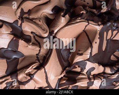 Gelato al cioccolato - dettaglio telaio completo. Primo piano di una superficie marrone di gelato al cioccolato ricoperto con una guarnizione di cioccolato fondente. Foto Stock