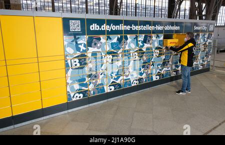 Lipsia, Germania. 24th Mar 2022. Un dipendente della Deutsche Post lavora su una stazione Packstation durante una presentazione alla stazione ferroviaria principale. Deutsche Bahn e Deutsche Post lanciano una collaborazione sulle stazioni di imballaggio. Credit: dpa/dpa-Zentralbild/dpa/Alamy Live News Foto Stock