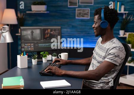 Regista uomo che modifica filmati su computer che lavora a progetti multimediali utilizzando software di post-produzione in Creativity studio. Videografo che crea effetti visivi per contenuti agengy. Lavoro a distanza Foto Stock