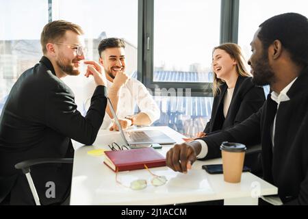 Gruppo di partner aziendali che si divertono a parlare durante una riunione in ufficio Foto Stock