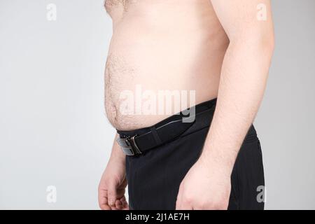 Un uomo con un ventre spesso da vicino. Obesità negli uomini, gonfiore Foto Stock