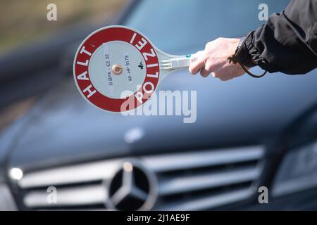 24 marzo 2022, Hessen, Francoforte sul meno: Un poliziotto ferma un'auto con una siviera che dice "polizia di arresto" a un checkpoint per la giornata di azione stradale della 'Spedmarathon'. Oggi si sta svolgendo una giornata di controllo a livello europeo, durante la quale si stanno prendendo di mira soprattutto i conducenti che accelerano. Foto: Sebastian Christoph Gollnow/dpa Foto Stock