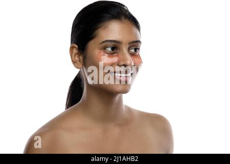 Bella donna indiana con le macchie idratanti degli occhi sotto i suoi occhi Foto Stock