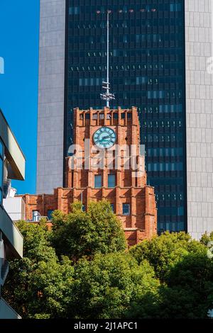 Giappone tra tradizione e modernità. Vista della torre dell'orologio di Hibiya Park Shisei Kaikan (Biblioteca Comunale) di fronte agli edifici moderni Foto Stock