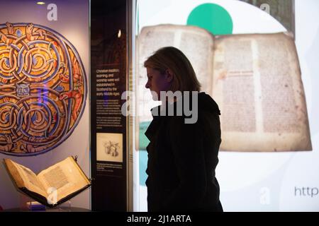Edimburgo. Scozia. REGNO UNITO. 24th marzo 2022. La Biblioteca Nazionale di Scozia mostra in casi come Timothy PontÕs carte rivoluzionarie, effetti del pioniere Isobel Wylie Hutchison, Charles DarwinÕs sull'origine della specie, una lettera di Ludwig van Beethoven, ScotlandÕs prime stampanti Chepman & Myllar, una Bibbia Gutenberg completa, prime edizioni internazionali di Harry Potter, E Robert BurnsÕs AE Fond Kiss. Nuova mostra chiamata: Tesori della Biblioteca Nazionale di Scozia. Nella foto: Direttore esecutivo e bibliotecario nazionale, Amina Shah guarda da vicino parte della mostra. Credito: Pako Foto Stock