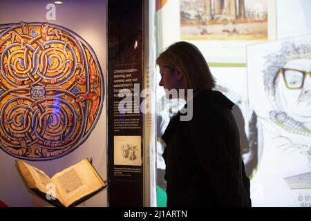 Edimburgo. Scozia. REGNO UNITO. 24th marzo 2022. La Biblioteca Nazionale di Scozia mostra in casi come Timothy PontÕs carte rivoluzionarie, effetti del pioniere Isobel Wylie Hutchison, Charles DarwinÕs sull'origine della specie, una lettera di Ludwig van Beethoven, ScotlandÕs prime stampanti Chepman & Myllar, una Bibbia Gutenberg completa, prime edizioni internazionali di Harry Potter, E Robert BurnsÕs AE Fond Kiss. Nuova mostra chiamata: Tesori della Biblioteca Nazionale di Scozia. Nella foto: Direttore esecutivo e bibliotecario nazionale, Amina Shah guarda da vicino parte della mostra. Credito: Pako Foto Stock