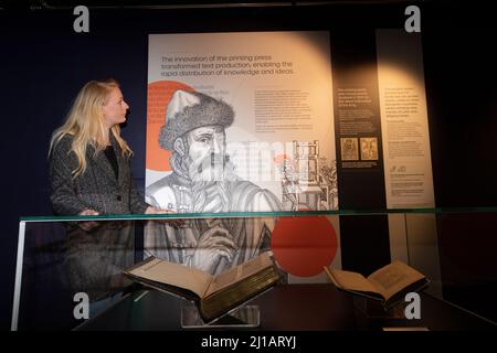 Edimburgo. Scozia, Regno Unito. 24th Mar 2022. La Biblioteca Nazionale di Scozia mostra in casi come Timothy PontÕs carte rivoluzionarie, effetti del pioniere Isobel Wylie Hutchison, Charles DarwinÕs sull'origine della specie, una lettera di Ludwig van Beethoven, ScotlandÕs prime stampanti Chepman & Myllar, una Bibbia Gutenberg completa, prime edizioni internazionali di Harry Potter, E Robert BurnsÕs AE Fond Kiss. Nuova mostra chiamata: Tesori della Biblioteca Nazionale di Scozia. Nella foto: Sarah Drummond dal dipartimento PR pose la prossima Bibbia di Gutenberg. Credit: Pako Mera/Alamy Live News Foto Stock