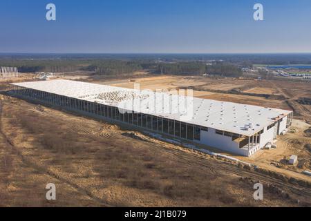 Vasta pianura, cantiere, costruzione di una grande sala industriale. Vista dal drone. Foto Stock