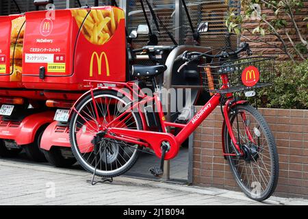 TOKYO, GIAPPONE - 17 marzo 2022: Una bicicletta elettrica di consegna McDonalds parcheggiata da uno scooter di consegna ad un ristorante McDonalds nel Koto Ward di Tokyo. Foto Stock