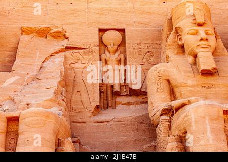 Statua del faraone seduto Ramesses II e Ra Horakhty al Grande Tempio di Rameses II ad Abu Simbel Village, Assuan, Alto Egitto. Foto Stock