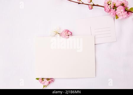 Primavera delicato cartolina con posto per indirizzo e carta di cancelleria mock up con fiori rosa e bianco. Giorno della donna, invito, giorno della madre, romano Foto Stock