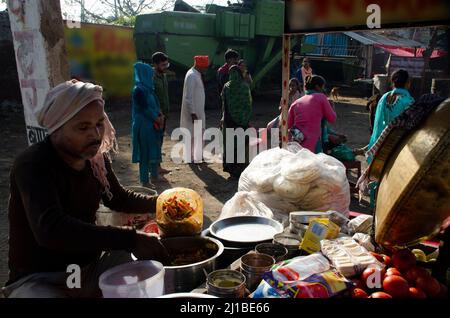 Un venditore di cibo di strada che vende fast food durante Holi a Mathura, India. Foto Stock