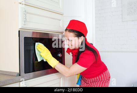 Casalinga pulizia forno a microonde con spugna in cucina, vista  dall'interno Foto stock - Alamy