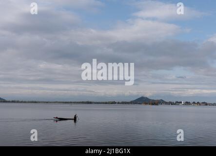 Srinagar, India. 24th Mar 2022. Un uomo fa la sua barca sul lago durante una nuvolosa giornata di primavera a Srinagar. (Foto di Idrees Abbas/SOPA Images/Sipa USA) Credit: Sipa USA/Alamy Live News Foto Stock