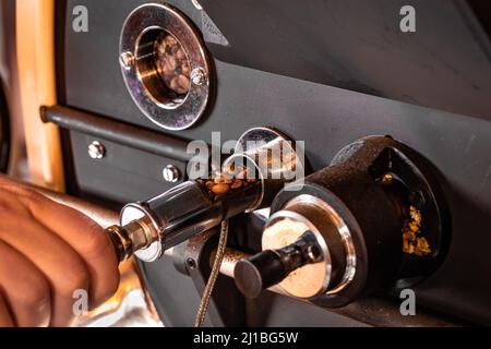 Controllo manuale della produzione di caffè torrefatto Foto Stock