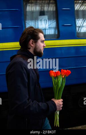 24 marzo 2022, Lviv, Lviv Oblast, Ucraina: Un uomo caries i fiori ad un treno che porta i rifugiati fuori da Mariupol. Alla stazione ferroviaria di Lviv arrivò un treno che trasportava rifugiati provenienti da Mariupol, dilaniata dalla guerra. Molti continueranno il loro viaggio da Lviv fuori dall'Ucraina. (Credit Image: © Ty ONeil/SOPA Images via ZUMA Press Wire) Foto Stock