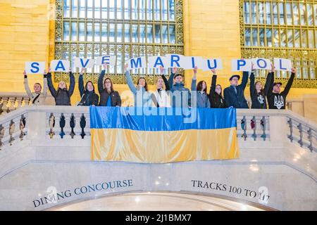 New York, New York, Stati Uniti. 23rd Mar 2022. Ucraina Flash Mob nel Grand Central Staion NYC. I manifestanti durante il viaggio serale mostrando il loro sostegno per l'Ucraina contro Putin e l'invasione dell'Ucraina indipendente da parte della Russia.Flash mob svelato grande bandiera e lettere ortografia Salva. Mariupol sul balcone del terminal. (Credit Image: © Milo Hess/ZUMA Press Wire) Foto Stock