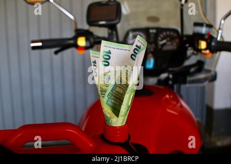 Soldi per il carburante su un motociclista Foto Stock