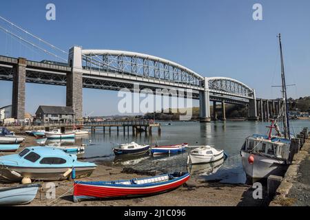 Saltash Waterfront con barche sulla spiaggia accanto al fiume Tamar e il Royal Albert Bridge e Tamar Road Bridge che collegano Devon alla Cornovaglia Foto Stock