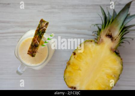 Frullato di ananas Mango Banana fatto in casa in un vaso di vetro, vista dall'alto. Disposizione piatta, sovratesta, dall'alto. Foto Stock