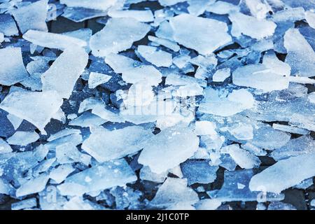 Schegge di ghiaccio rotto sul marciapiede. Vista dall'alto. Pulizia del marciapiede e dei sentieri dal ghiaccio. Foto Stock