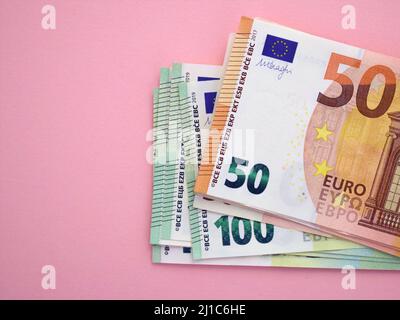 Confezione di banconote in euro su sfondo rosa. Valuta europea, affari, finanza. 50 e 100 euro Foto Stock