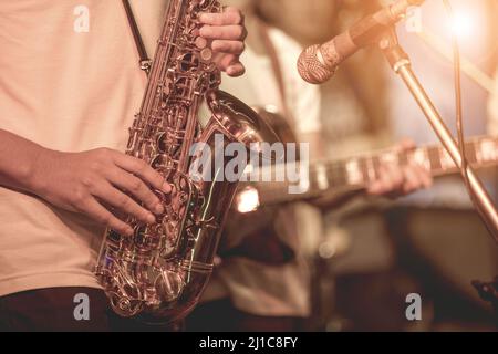 Strumenti musicali, sassofono player mani sassofonista che suona musica jazz. Alto sax strumento musicale primo piano Foto Stock