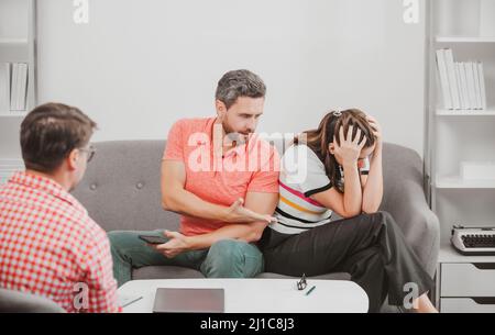 Psicologo dell'operaio sociale che parla con la giovane coppia. Coppia che dice allo psicologo circa i problemi della famiglia coniugale. Consulenza matrimoniale, coniugale Foto Stock