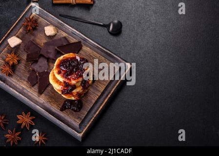 Frittelle di formaggio caserario, sciroppi, frittelle di ricotta su un tagliere di legno. Dolci fatti in casa Foto Stock