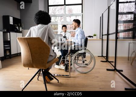 Disabili imprenditore maturo seduto alla scrivania con computer portatile in sala conferenze Foto Stock