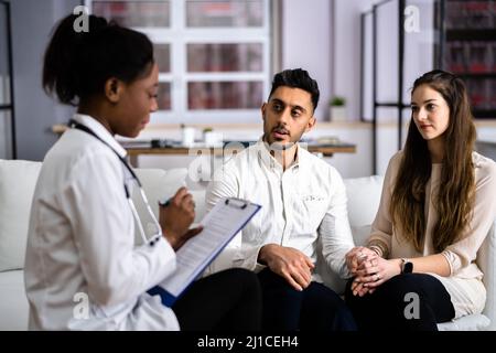 Coppia incinta e medico a casa Pregnancy test Foto Stock