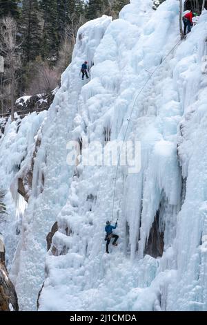 Un arrampicatore a destra sale come un altro arrampicatore a sinistra si arrampica su una parete di ghiaccio alta 160' nel Parco di ghiaccio di Ouray, Colorado. Foto Stock