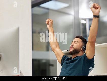 Risolvere i problemi per i miei chiamanti è quello che faccio meglio. Scatto di un giovane uomo d'affari che guarda allegro mentre lavora in un call center. Foto Stock