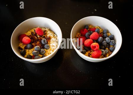 Cereali da colazione con more e lamponi su sfondo nero Foto Stock