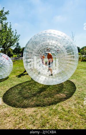 I bambini hanno un sacco di divertimento nella sfera Zorbing Foto Stock