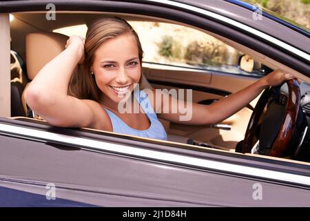 Im a casa dietro il volante. Una donna seduta in un'auto di lusso. Foto Stock