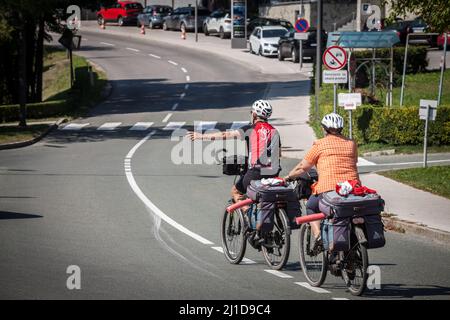 Foto di due anziani, uomo e donna, una coppia, che fanno un giro in bicicletta a Bled, nelle alpi slovene, con le loro biciclette. Il tour in bicicletta è il Foto Stock