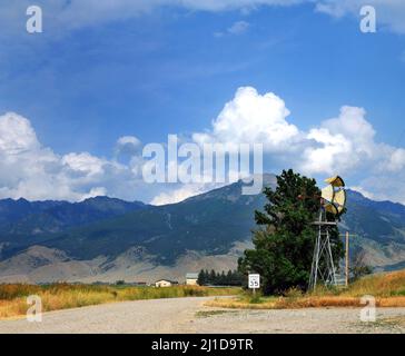 L'incrocio è contrassegnato da un segnale di limite di velocità di 35 mph. Windmill si trova all'angolo di dove si incontrano queste due strette strade di ghiaia. I monti Absaroka si trovano in b Foto Stock