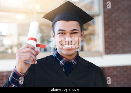 Un investimento nella conoscenza paga l'interesse migliore. Ritratto di un giovane studente il giorno della laurea. Foto Stock