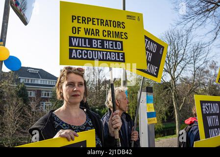 L'Aia, Paesi Bassi. 24th Mar 2022. I manifestanti tengono le etichette durante la dimostrazione. I membri di Amnesty International si sono riuniti al di fuori dell'ambasciata russa all'Aia, per celebrare un mese al giorno in cui la Russia ha invaso il territorio neutrale dell'Ucraina. (Foto di Charles M Vella/SOPA Images/Sipa USA) Credit: Sipa USA/Alamy Live News Foto Stock