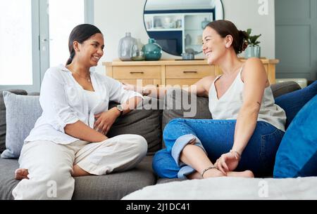 Niente batte una sessione di legame con gli amici. Scatto di due giovani donne sedute sul divano insieme a casa e che si legano durante il giorno. Foto Stock