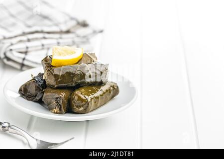 Dolmades. Foglie di vite ripiene. Antipasto greco sul piatto. Foto Stock