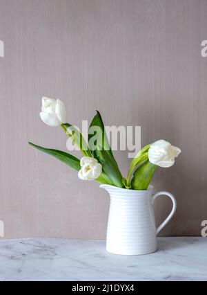 Tre tulipani bianchi in vaso in ceramica. Minimalismo. Casa accogliente. Foto Stock